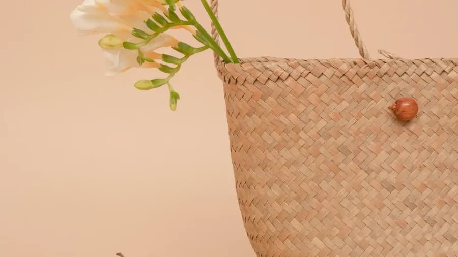 Cesta de mimbre con flores y una manzana verde